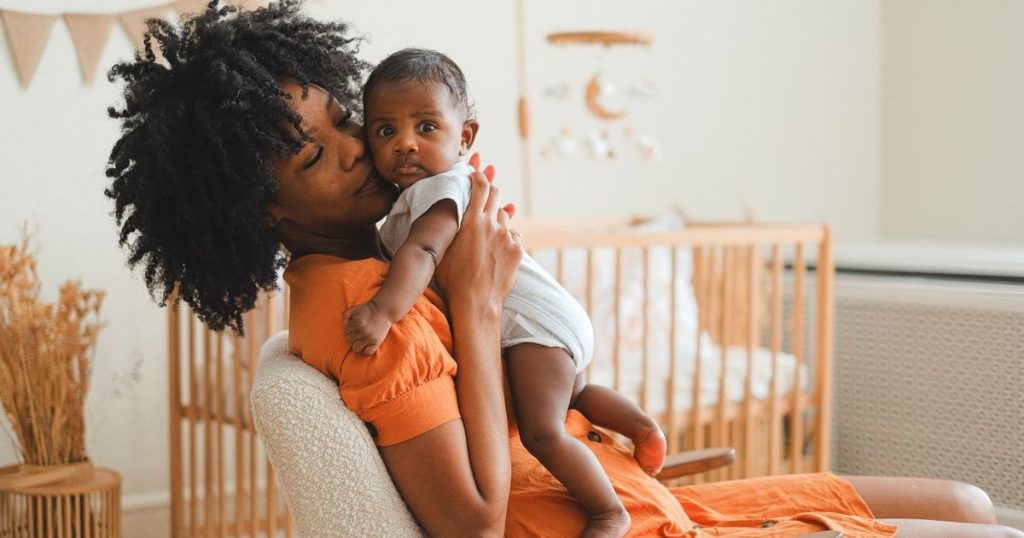 Parent soothing and cuddling a baby in a nursery