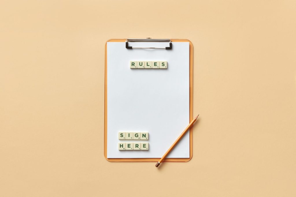 Blank clipboard and a pencil on a peach background