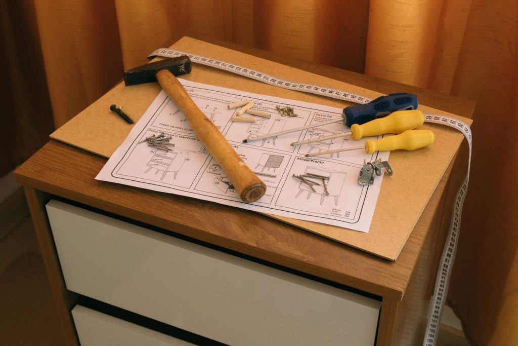 Hammer, pencils and an instruction sheet on a workbench