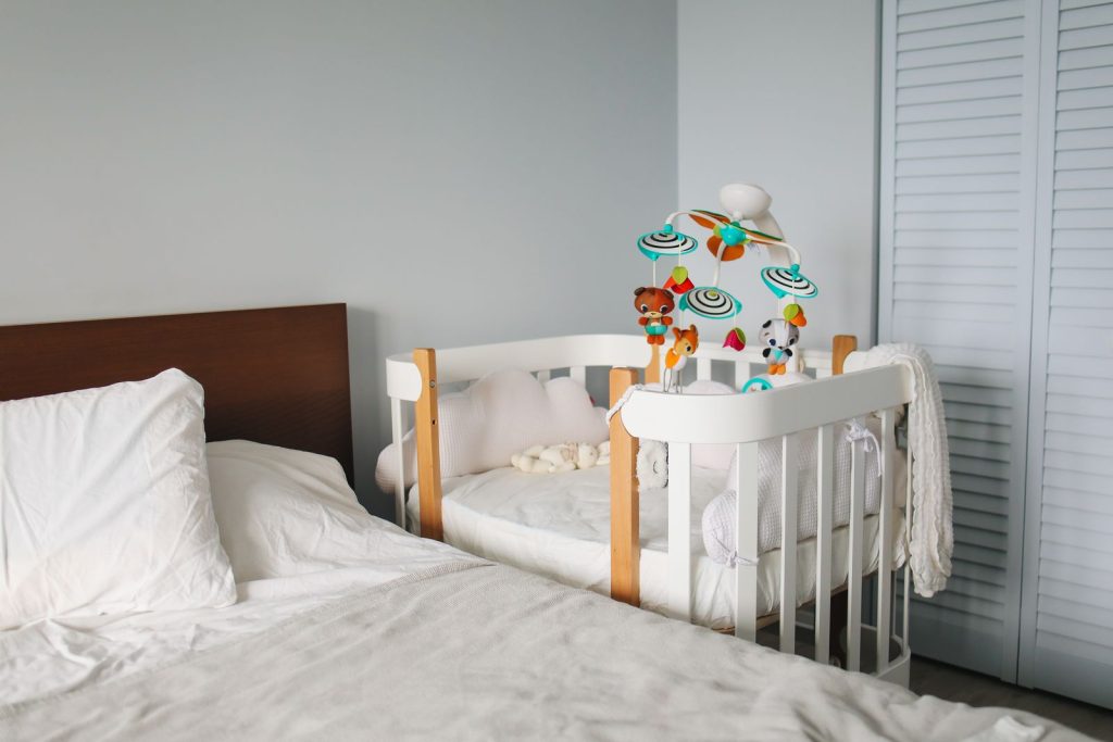 Bedside crib attached to an adult bed