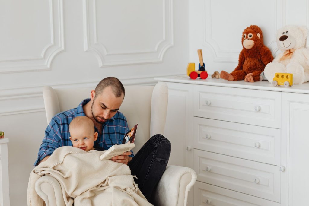 Father sitting in an armchair with his baby on his lap
