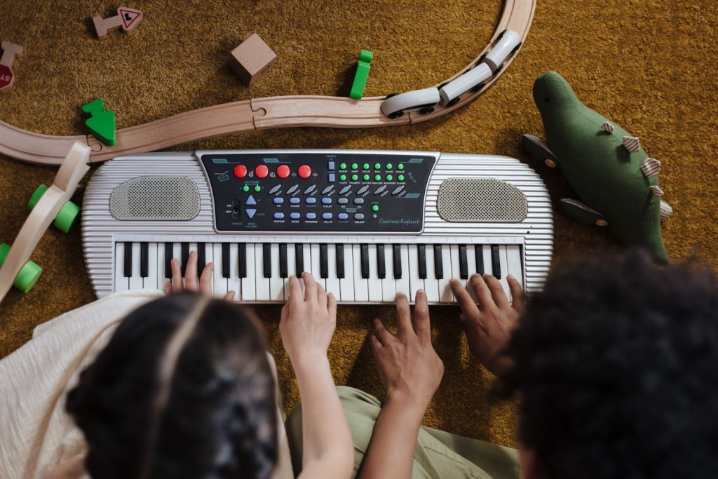 Children’s hands playing a toy keyboard
