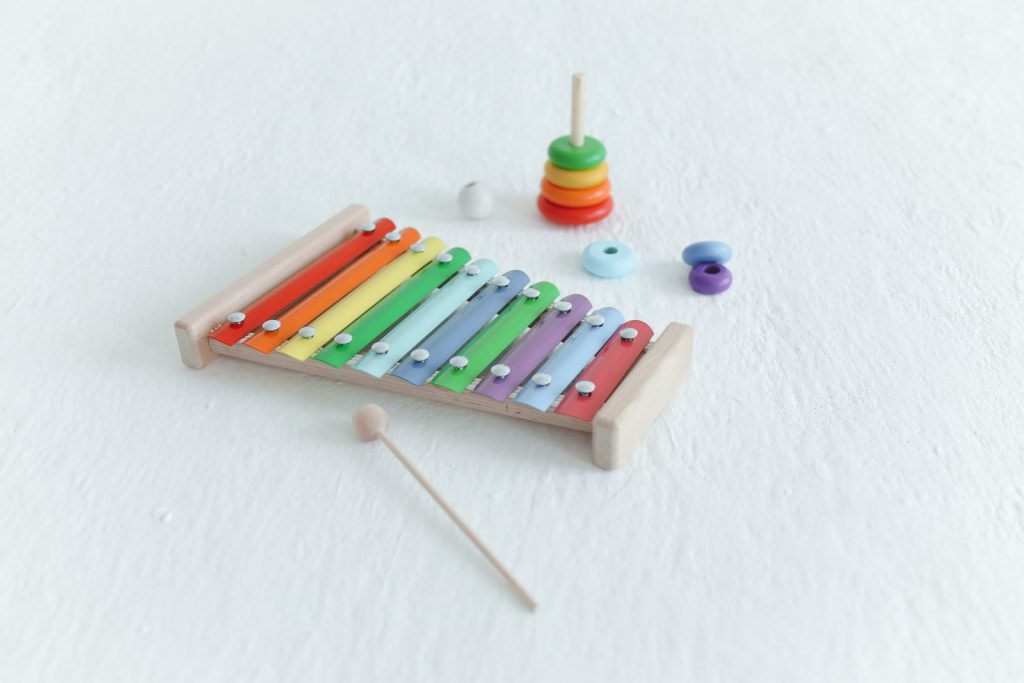 Toy xylophone and a wooden stacking toy on a white surface