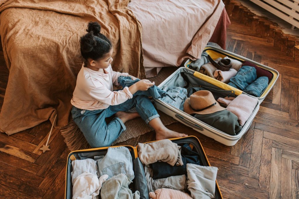 Woman packing a suitcase on a bed, seen from above