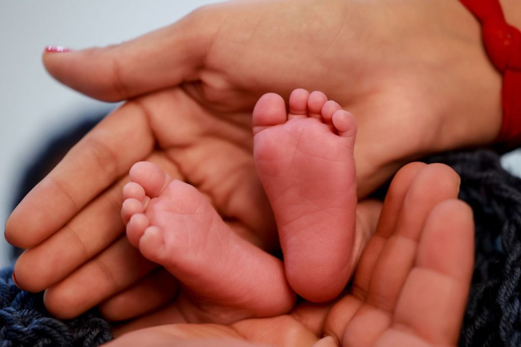 Adult hands cupping a baby’s feet