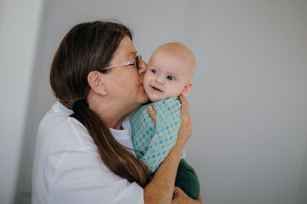 Grandmother kissing a baby on the cheek