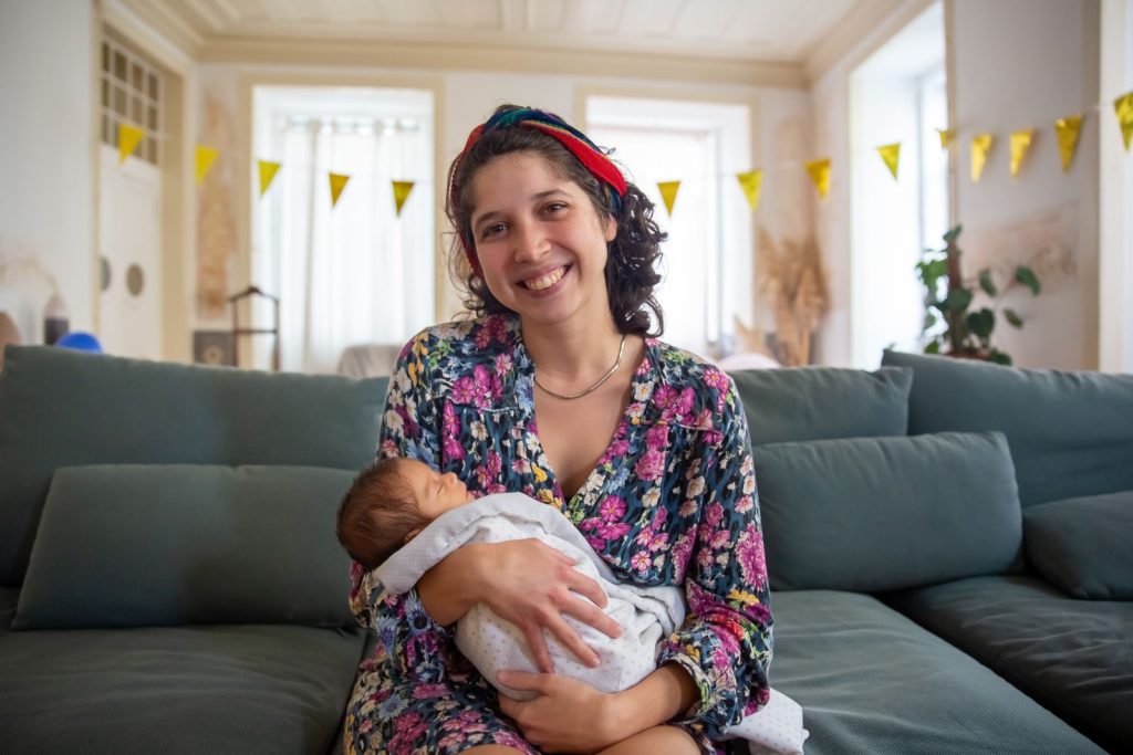 Mother sitting on a sofa holding her baby