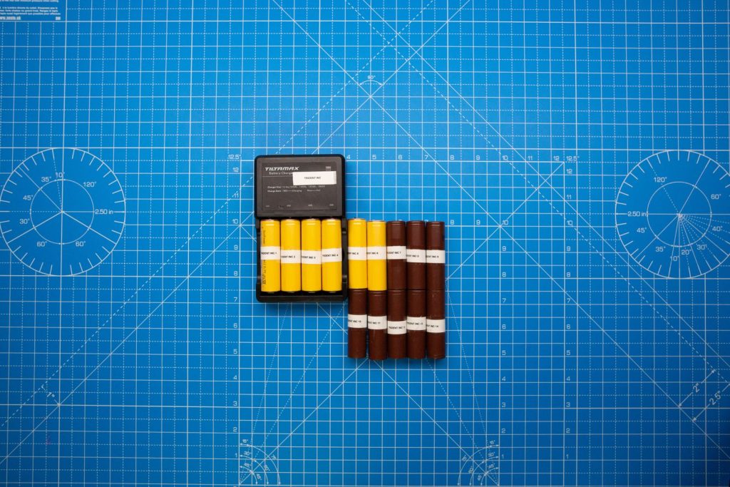 Batteries in holders on a blue cutting mat
