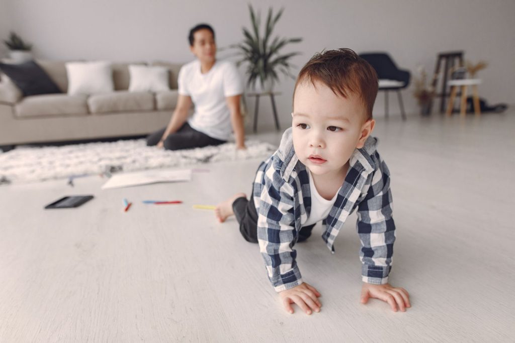 Baby crawling across a living room floor